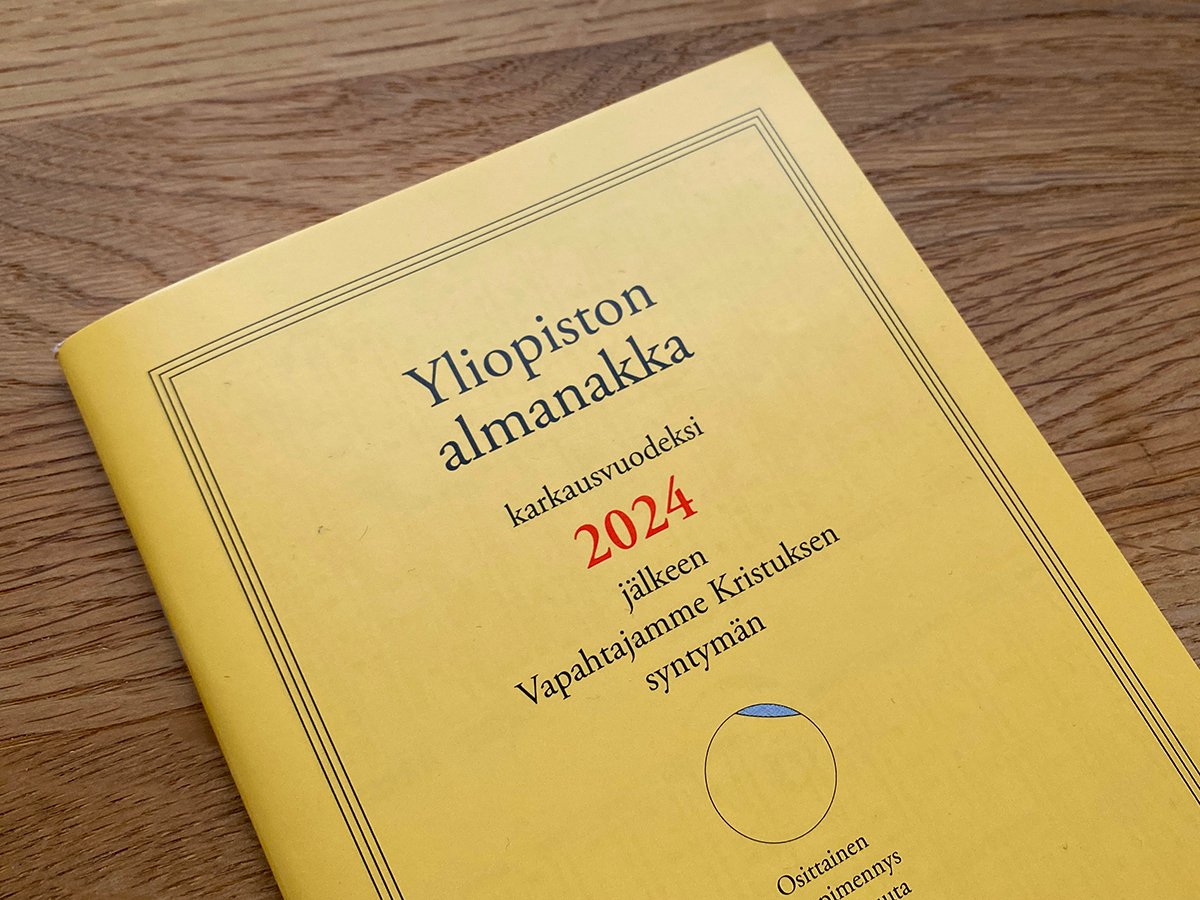 Vuoden 2024 Yliopiston almanakan kansikuva tammipöydällä