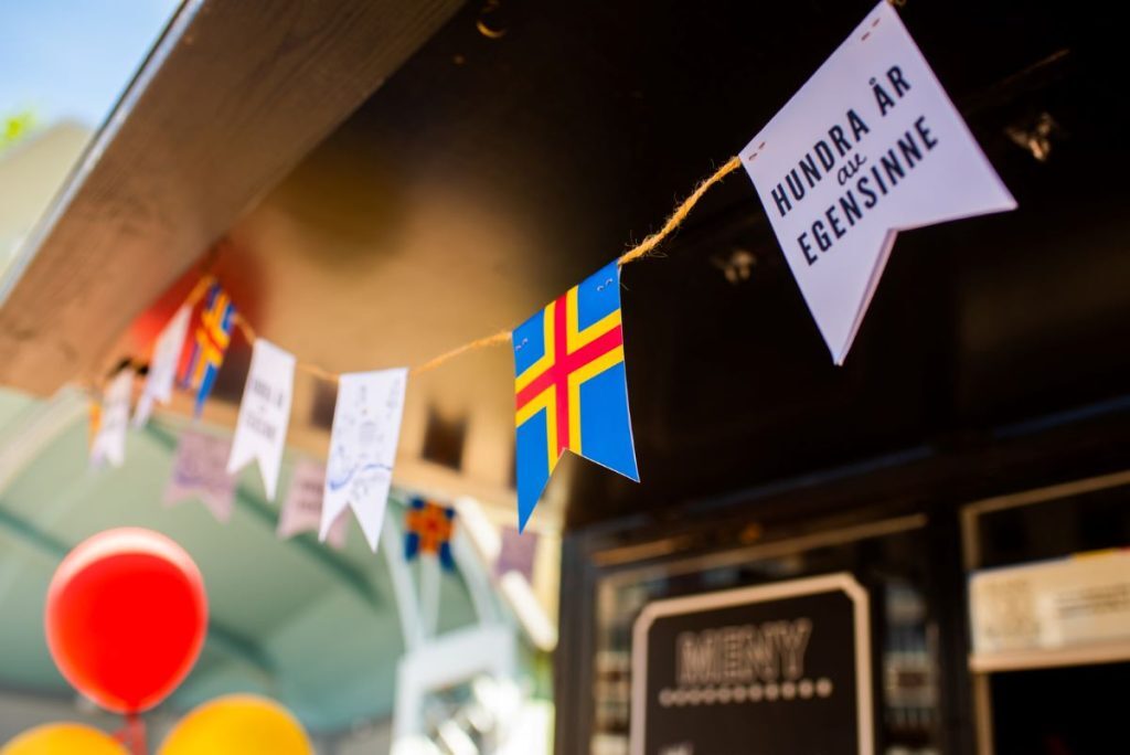 Kioskin katossa roikkuva viirinauha, jossa on Ahvenanmaan lippu.